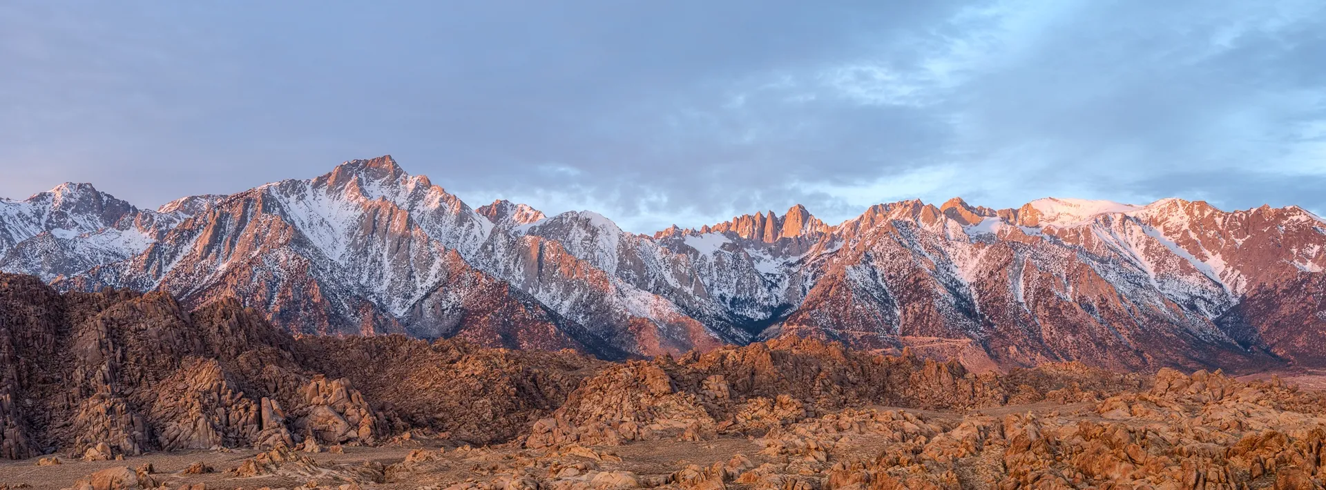 The full sweep of the Sierra Nevada in winter — California's highest peaks in panoramic format, morning light on the snow. Photograph by Marty Quinn